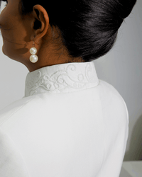 Back of the Noor's stand collar with embroidery wrapping the neckline and a clean ventless back