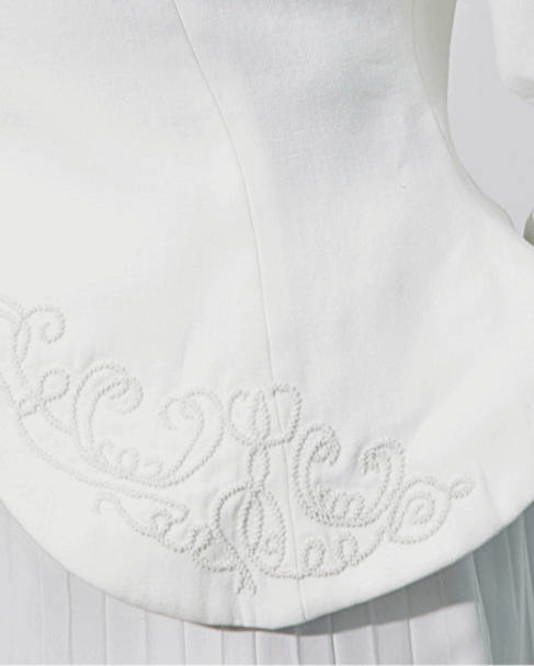 Detail of the Noor's boned front hem panel embroidered with baroque white bead scrollwork